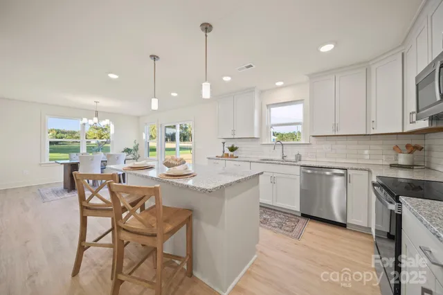 a kitchen with a dining table chairs sink and cabinets