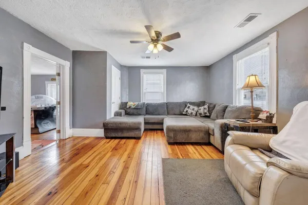 a living room with furniture and a wooden floor