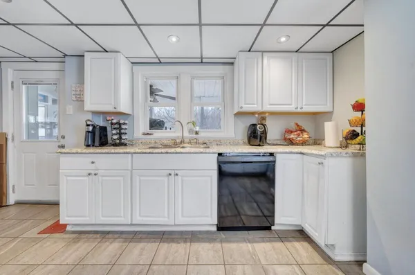 a kitchen with a sink window and cabinets