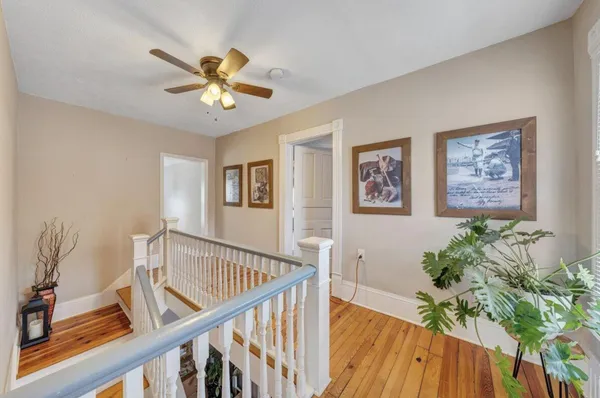 a view of a livingroom with wooden floor and a ceiling fan