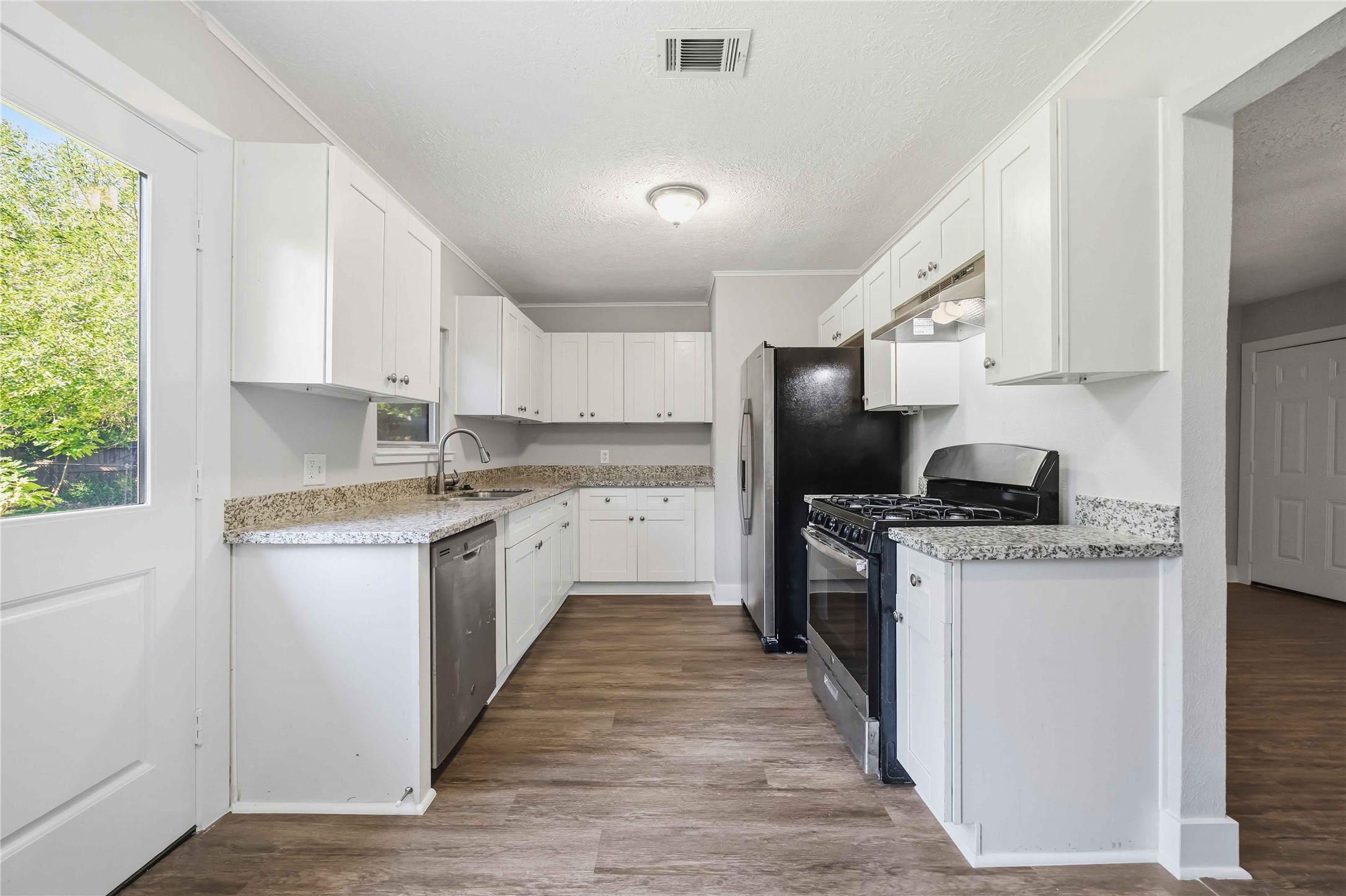 113 East Witcher Lane Houston, TX 77076 - Photo 10 of 21 a kitchen with stainless steel appliances granite countertop a stove top oven a sink dishwasher and a refrigerator