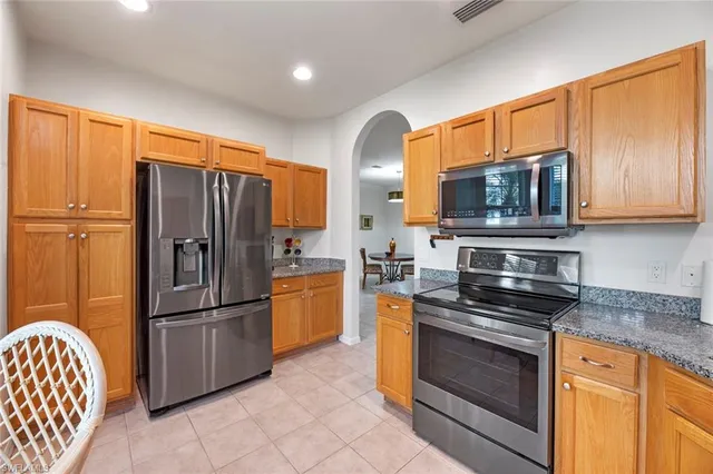 a kitchen with stainless steel appliances granite countertop a refrigerator stove and microwave