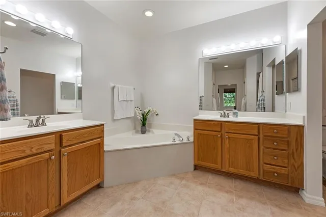 a spacious bathroom with a granite countertop sink double and mirror