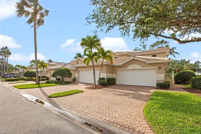 a front view of a house with a yard and palm trees