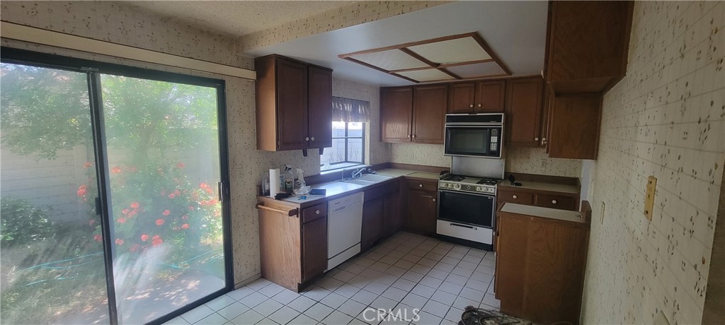 4 Dearborn Circle Redlands, CA 92374 - Photo 7 of 17 a kitchen with stainless steel appliances granite countertop a refrigerator a stove top oven a sink and dishwasher