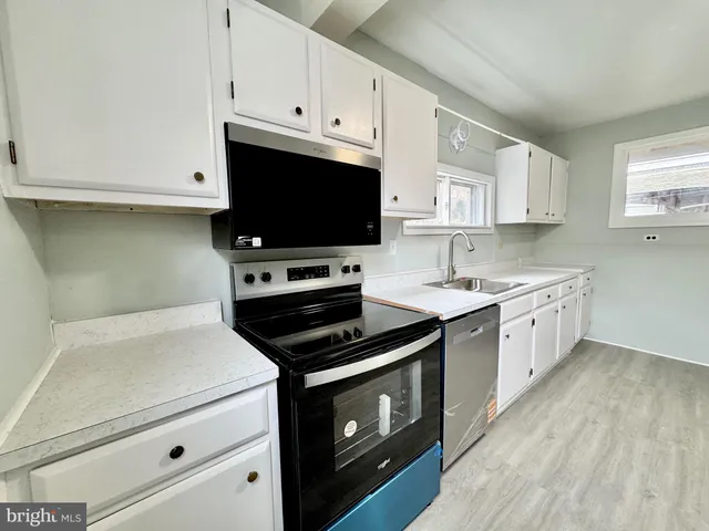 a kitchen with white cabinets and white appliances