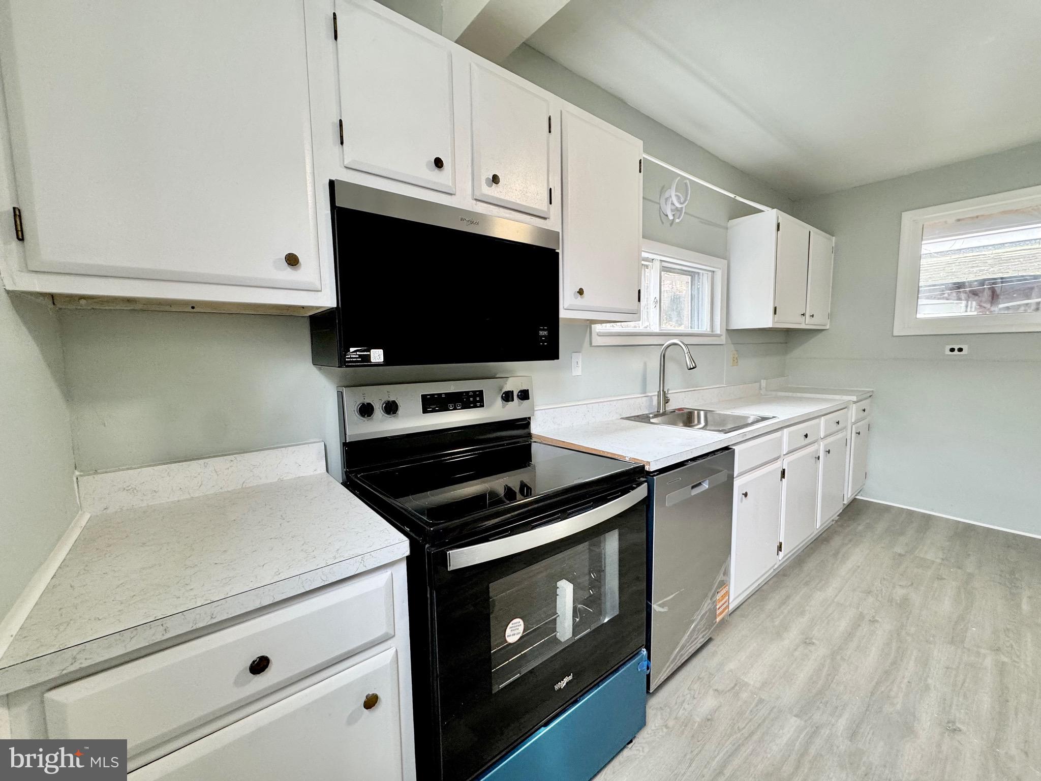 467 Goethe Street Cumberland, MD 21502 - Photo 9 of 19 a kitchen with white cabinets and white appliances