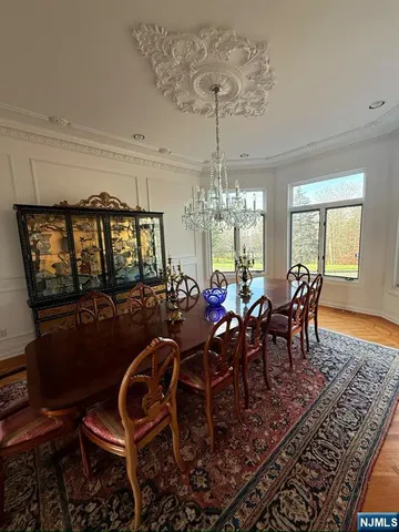 a view of a dining room with furniture a chandelier and wooden floor
