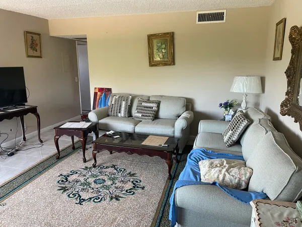 a living room with furniture lamp and rug