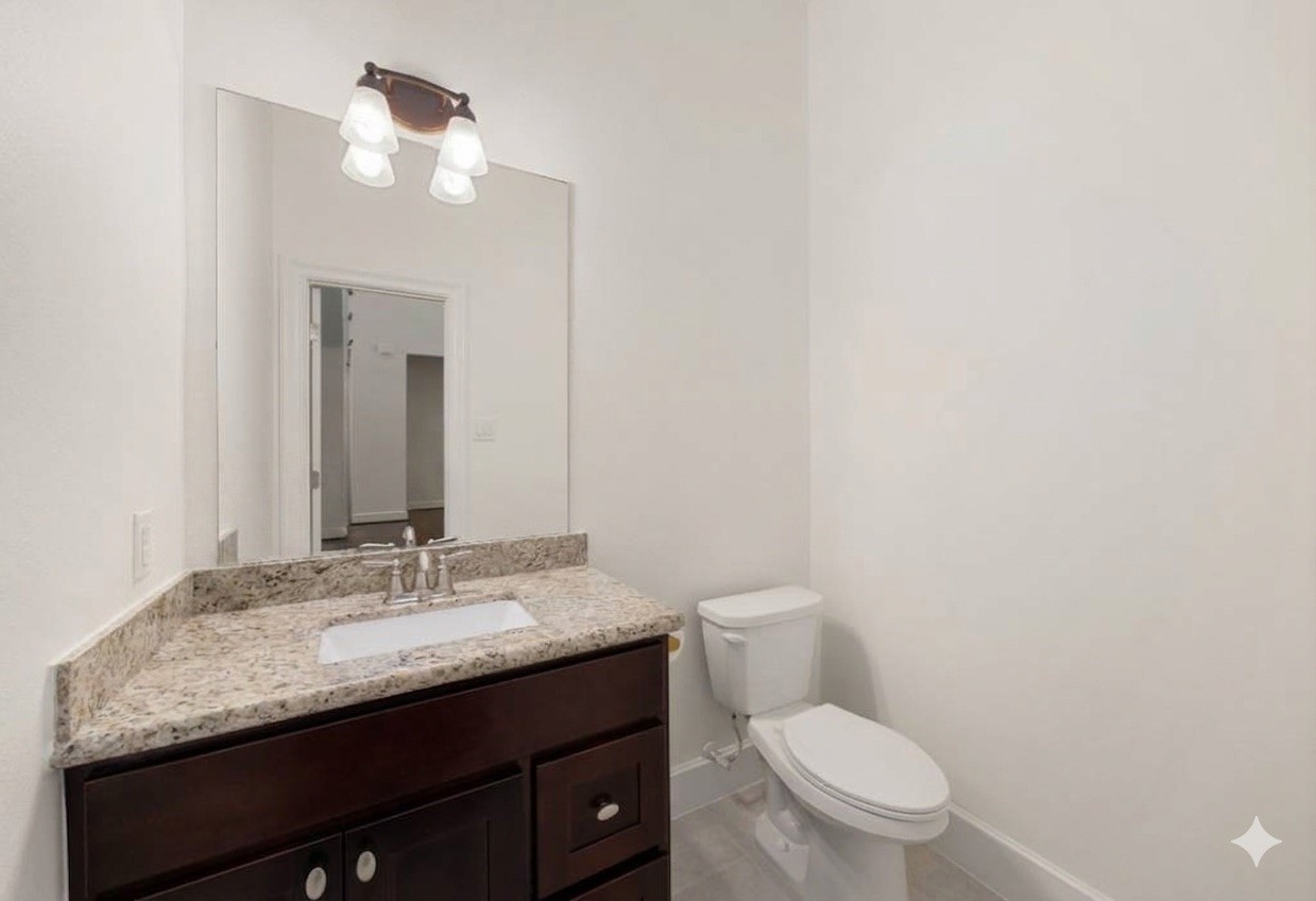 1904 Boulder Ridge Drive Conroe, TX 77304 - Photo 15 of 37 This crisp and neutral powder room features a dark wood vanity topped with beautiful granite counters. A large frameless mirror and an updated light fixture help keep the space feeling bright, open, and inviting for your guests.