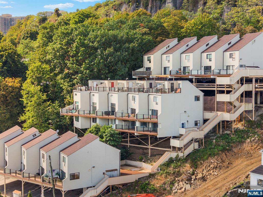 101 Highway 5, Unit 206 Edgewater, NJ 07020 - Photo 43 of 48 a view of a white house next to a yard with plants and trees