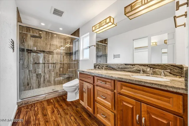 a bathroom with a double vanity sink toilet and shower
