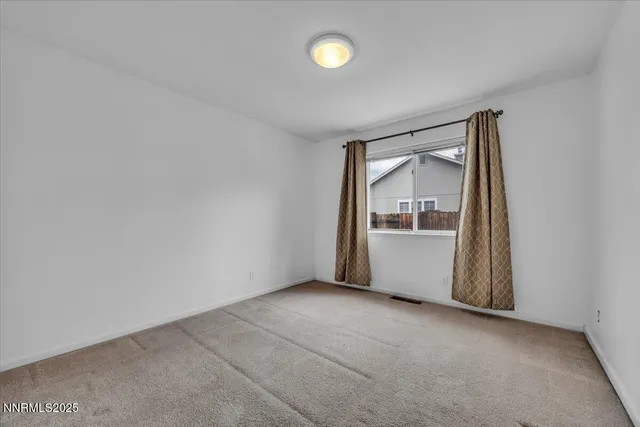 a view of an empty room with a fireplace and a window