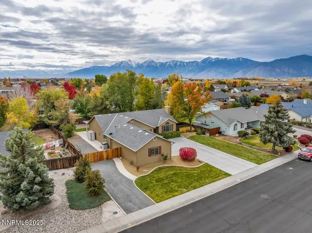 an aerial view of residential houses with outdoor space and trees