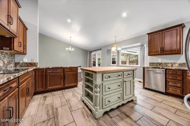 a kitchen with stainless steel appliances kitchen island granite countertop a stove a sink and a microwave