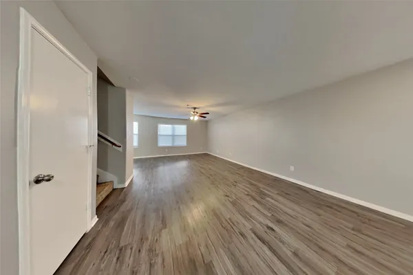 an empty room with wooden floor and a window