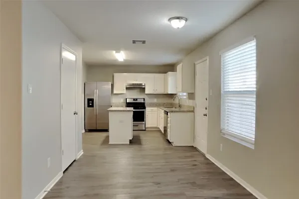 a kitchen with white cabinets and white appliances