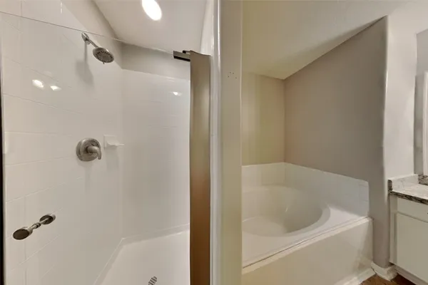 a bathroom with a white bath tub and a shower
