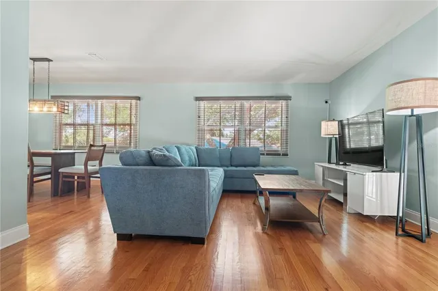 a living room with furniture a flat screen tv and wooden floor
