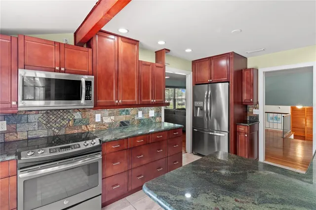 a kitchen with stainless steel appliances granite countertop a refrigerator stove and microwave