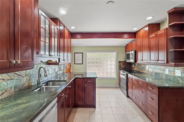 a kitchen with stainless steel appliances granite countertop a sink stove and cabinets