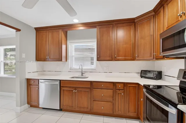a kitchen with stainless steel appliances granite countertop a refrigerator a stove and a sink with cabinets