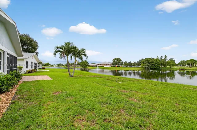 a front view of a house with a yard and potted plants