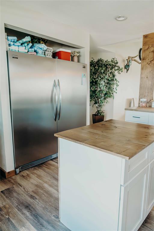 1740 Highway 2247 Comanche, TX 76442 - Photo 11 of 38 Kitchen with stainless steel refrigerator, butcher block counters, wood finished floors, white cabinetry, and recessed lighting