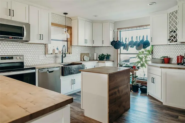 a kitchen with a sink dishwasher stove and wooden cabinets