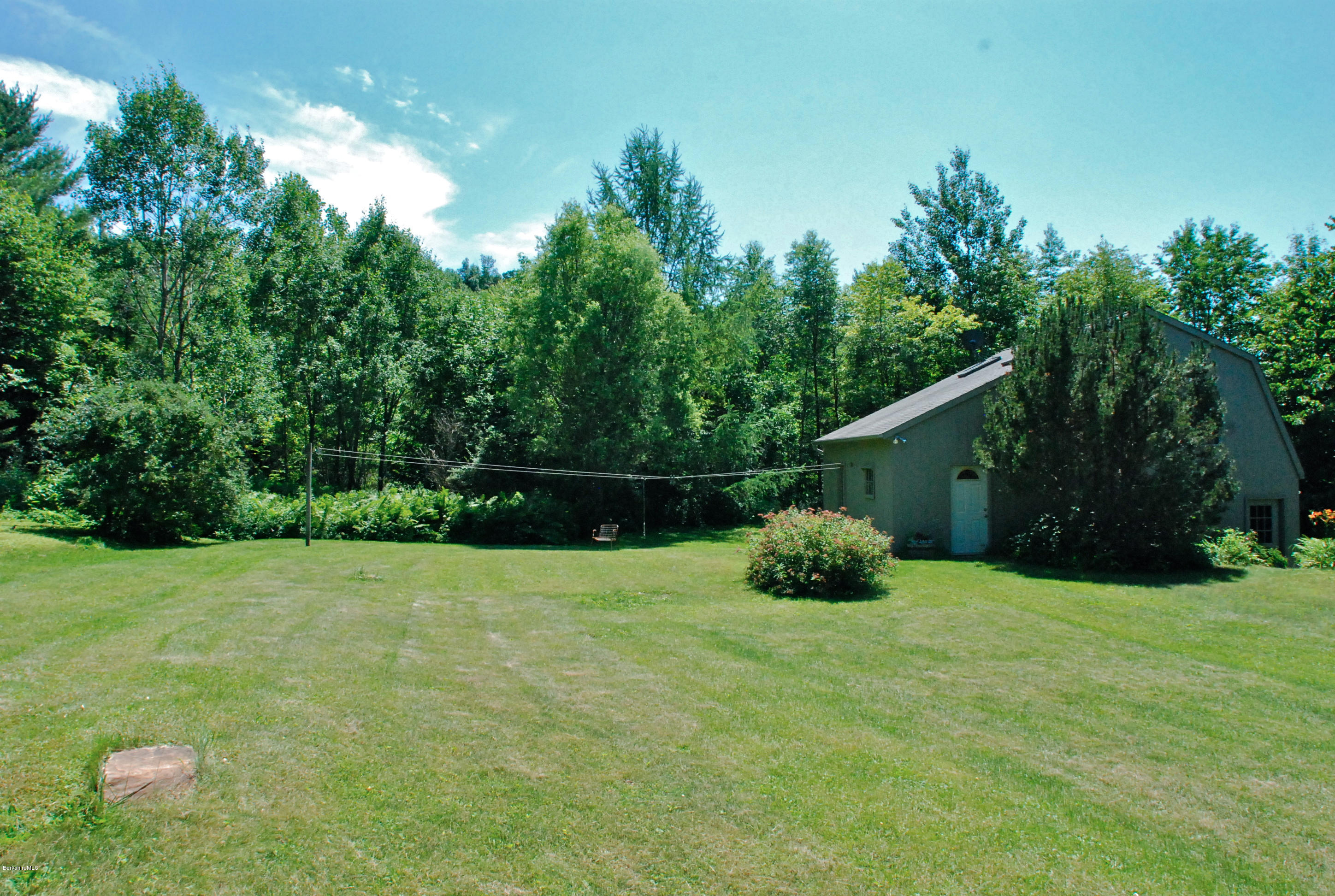 49 River Road Monterey, MA 01245 - Photo 38 of 43 a backyard of a house with potted plants and large tree