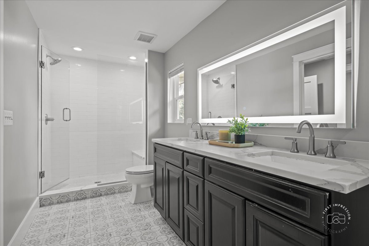 51 Burgess Road Geneva, IL 60134 - Photo 16 of 32 a bathroom with a double vanity sink mirror and shower