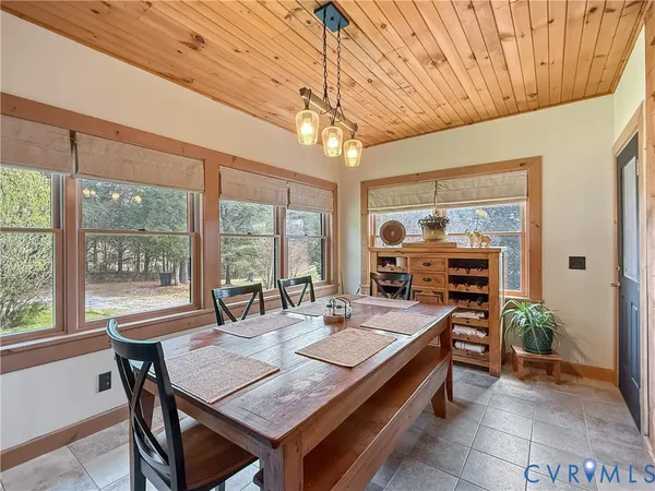 a dining room with furniture a chandelier and wooden floor