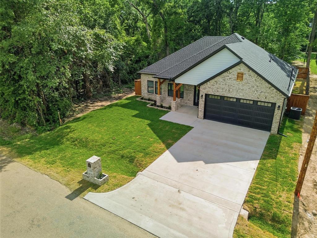 429 Waterboard Road Trinidad, TX 75163 - Photo 2 of 25 Contemporary single-story residence featuring a light brick exterior, a dark shingled roof, and a two-car garage with a dark sectional door