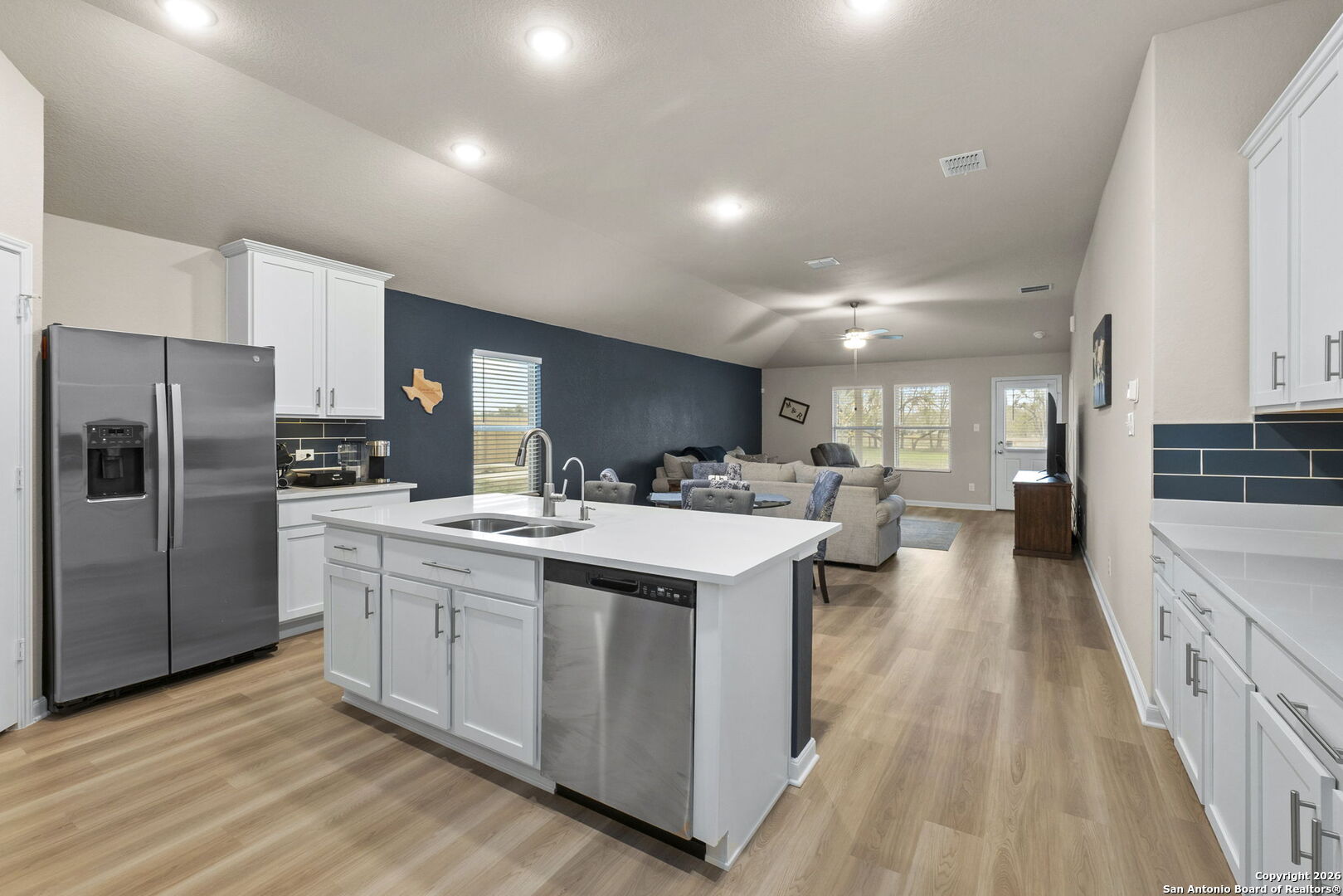 20825 Pleasanton Road San Antonio, TX 78264 - Photo 13 of 33 a kitchen with counter top space a sink wooden floor and stainless steel appliances