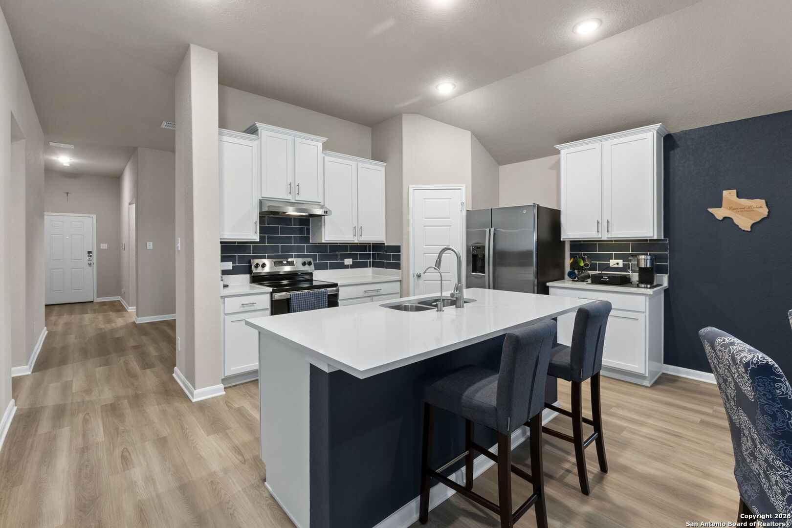 20825 Pleasanton Road San Antonio, TX 78264 - Photo 7 of 33 a kitchen with stainless steel appliances a kitchen island hardwood floor sink stove dining table and chairs
