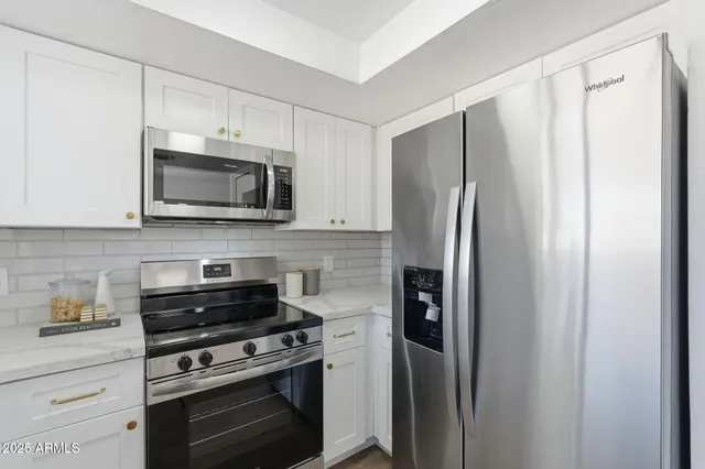 a kitchen with stainless steel appliances a refrigerator stove and microwave