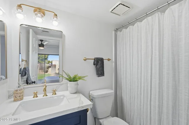a bathroom with a sink a toilet and shower curtain