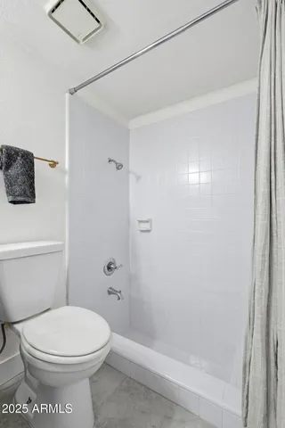 a bathroom with a toilet and a shower