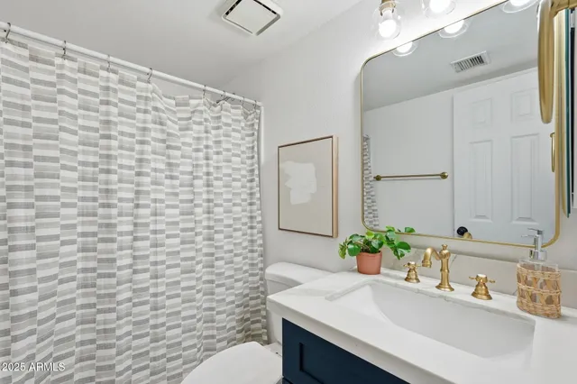 a bathroom with a sink a toilet and mirror
