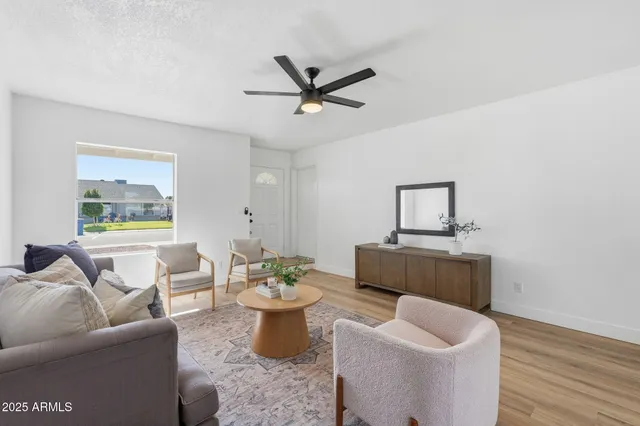 a living room with furniture a window and a wooden floor
