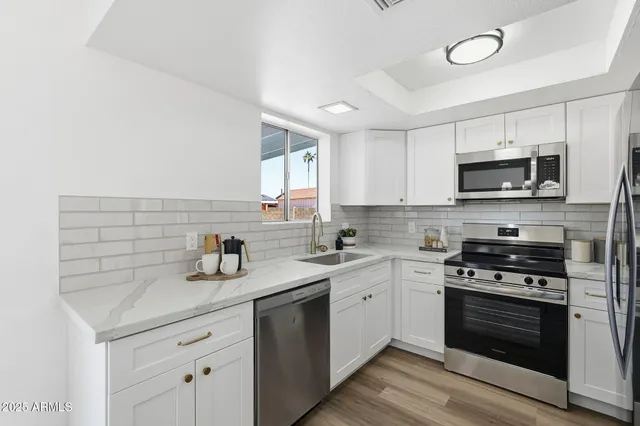 a kitchen with stainless steel appliances a stove sink microwave and cabinets