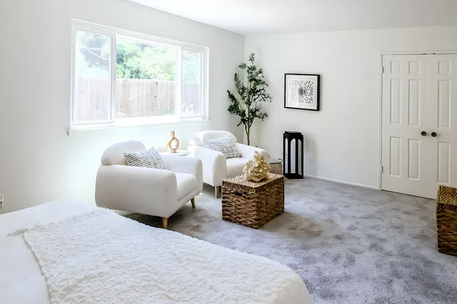 a bedroom with furniture and a large window