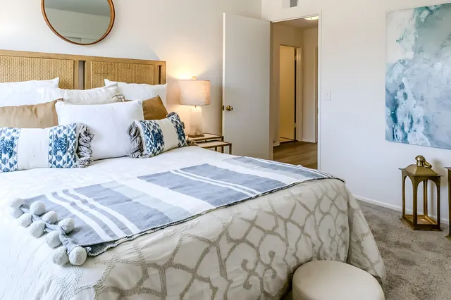 a bedroom with a bed and a painting on the wall