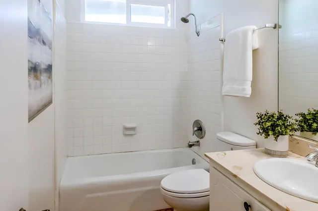 a bathroom with a sink a toilet a mirror and shower