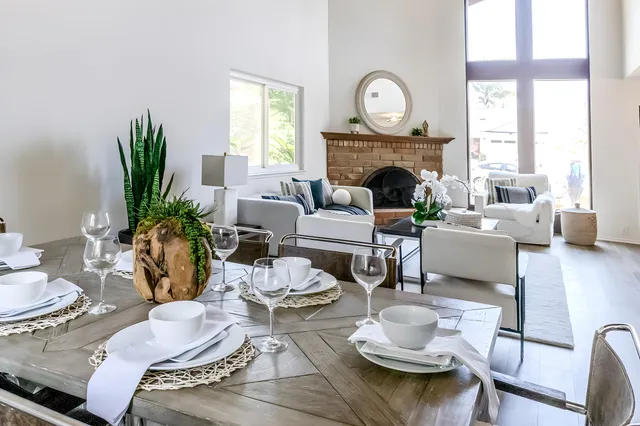 a living room with furniture a fireplace and a large window