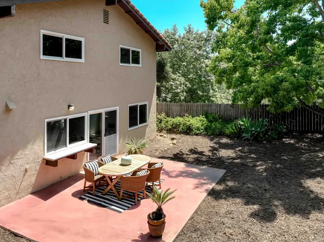 a backyard of a house with table and chairs