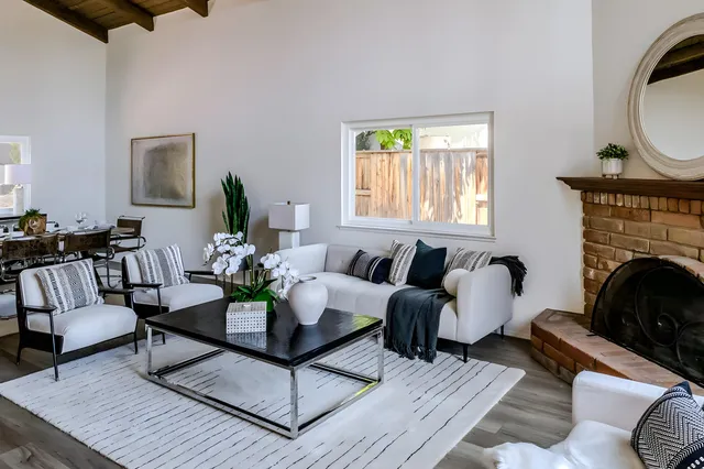 a living room with furniture large window and a fireplace