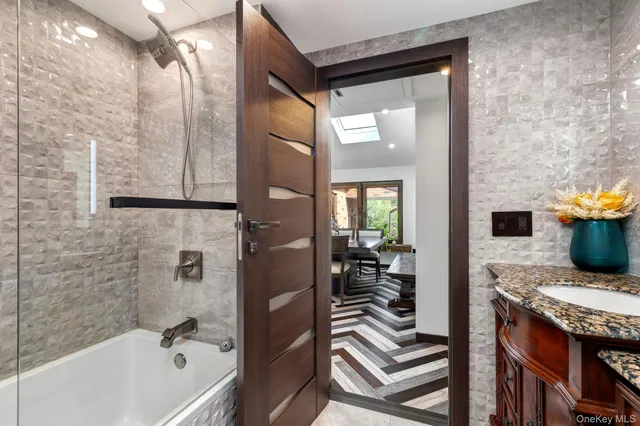 a bathroom with a granite countertop sink and a bathtub