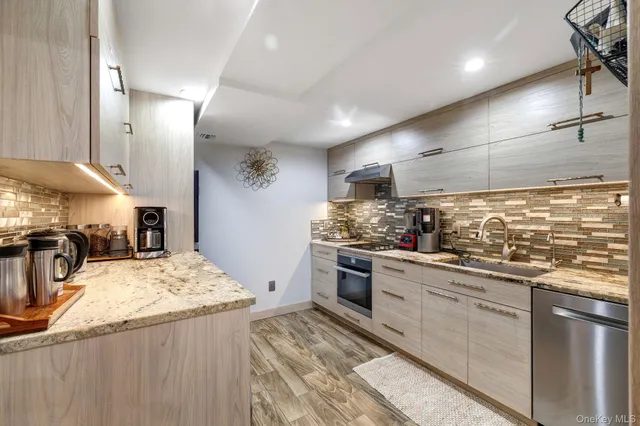 a kitchen with stainless steel appliances granite countertop a sink stove and refrigerator