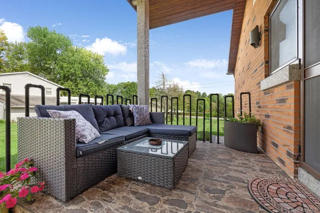 a roof deck with couches and potted plants
